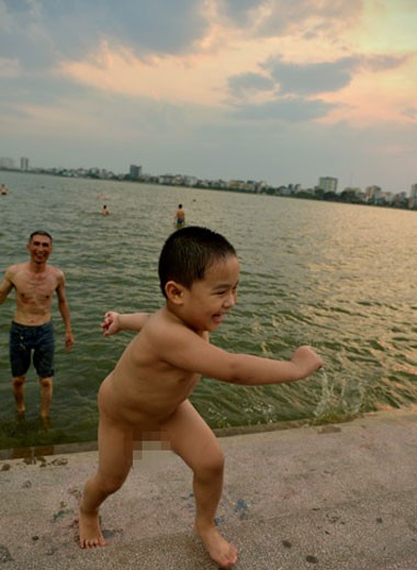 Cậu bé thỏa thích nô đùa khi được người thân cho đi giải nhiệt ở "bể bơi" Hồ Tây.