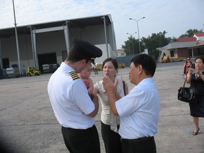 Ông Đoàn Quốc Việt (bên phải) chuyện trò cùng 1 cặp vợ chồng phi công Mỹ trong chuyến bay khai trương. Ảnh: Đình Thắng.