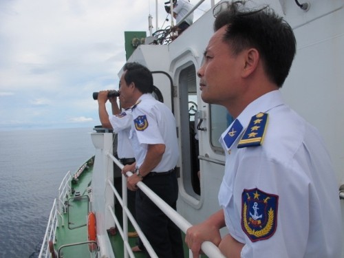 Các chiến sĩ cảnh sát biển sử dụng ống nhòm quan sát những chiếc tàu cá lạ từ xa..