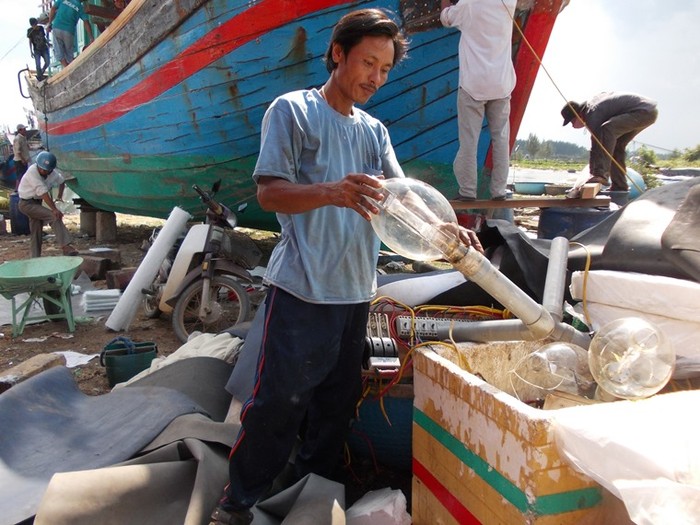 Ngư dân Huỳnh Văn Lắm đang gỡ dàn đèn câu cá ngừ đại dương xuống
