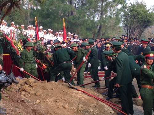 Bộ đội chuyển cát vào lấp mộ phần - Ảnh: Nguyễn Tú/thanhnien