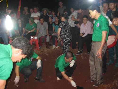 Thúy (đối tượng ngồi ghế, tay trái cầm đèn pin) tại buổi đào tìm hài cốt liệt sĩ vào lúc 20 giờ 26 phút ngày 29-1, ở thị xã Bình Long, tỉnh Bình Phước.