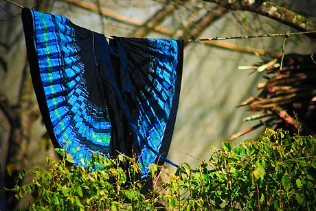 Những chiếc váy xanh ngát của người Mông được phơi ở những bờ giậu trước hoặc sau nhà. Ảnh: VnExpress.