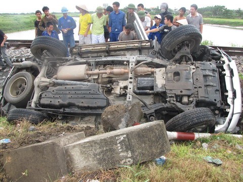 Hậu quả là chiếc Toyota Prado mất lái, lao sang bên đường ngược chiều, húc đổ cả biển báo giao thông và cột mốc trước khi lao xuống rãnh bê tông cạnh đường tàu. Ảnh: VnMedia.