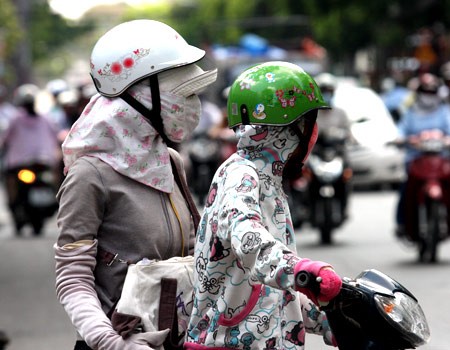 Để tránh nắng nóng, khi xuống phố, các cô luôn che chắn thật kỹ bằng găng tay, áo khoác, khăn che mặt và mũ vải bên trong mũ bảo hiểm. Ảnh: VnExpress