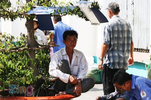 Bên hông chợ Bến Thành, một bác xích lô lấy bìa che lên tán lá cây làm chỗ tránh nắng...Ảnh: Zing