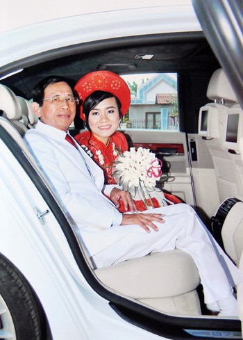 Cô dâu rạng rỡ bên chú rể gấp 3 lần tuổi mình song vẫn rất phong độ lịch lãm trong bộ vest trắng. Vợ chồng chụp hình trong chiếc BMW.
