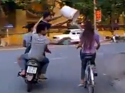 Ảnh chụp từ clip: Cận cảnh ba thanh niên hùa nhau tạt nước vào một cô gái đi xe đạp trên đường