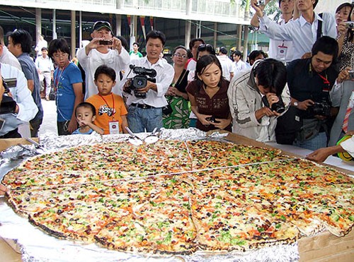 Chiếc pizza chay có đường kính 1,5 m, nặng 50 kg, được làm từ 18 kg bột mì, 10 kg bơ, hành tây, nấm mỡ, ớt chuông, cà rốt mỗi loại 4 kg, bông cải xanh, cà chua khô, olive đen mỗi loại 8 kg... Ảnh: Thoại Hà.