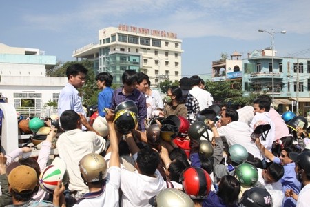 Người dân chen lấn, xô đẩy nhau để đổi được mũ bảo hiểm mới hôm 10/4. Ảnh: Dân trí.