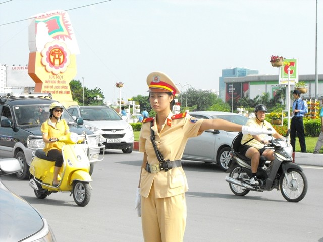 Nữ cảnh sát giao thông điều khiển các phương tiện giao thông dịp đại lễ 1000 năm Thăng Long – Hà Nội. Ảnh: Sỹ Lực/ Dân Việt.