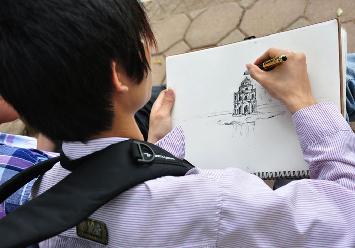 Chàng sinh viên kiến trúc miệt bài bên bức vẽ.