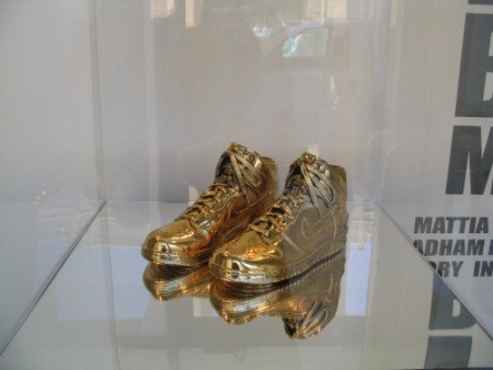 Tác giả đôi giày vàng là Kenneth Courtney, một người đàn ông đam mê vàng và từng thiết kế nhiều sản phẩm nổi tiếng đúc từ kim loại này. Ảnh: Nike High Dunk bên trong tủ kính phòng trưng bày của Nike.