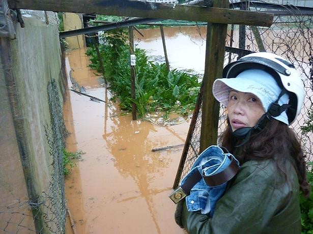 Một người dân hốt hoảng ôm quần áo chạy ra khỏi nhà khi nước lũ bất ngờ ập tới tại Đà Lạt.
