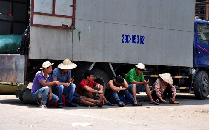 Tranh thủ thời gian nghỉ giải lao, những người lao động tận dụng khoảng râm của chiếc xe tải ghé lại để chống chọi.