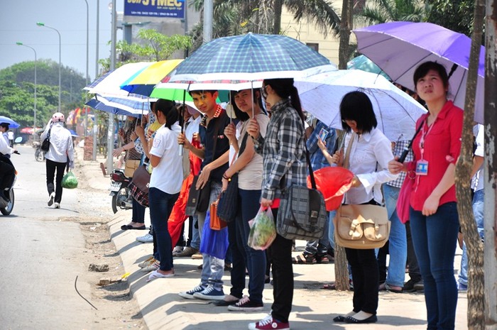 Những chiếc ô trong thời tiết nóng bức ở Hà Nội là vật dụng không thể thiếu với mọi người khi ra đường và lúc đợi xe buýt.