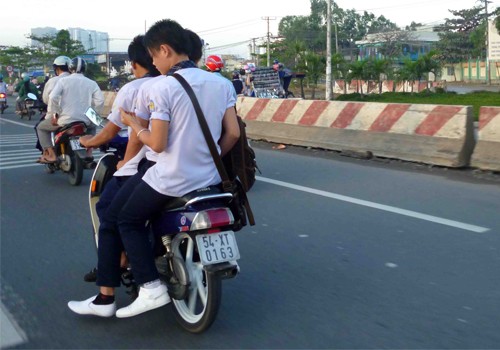 Học sinh chở 3 không đội mũ bảo hiểm. Ảnh: Nguyen Phuoc Thai Hoc.