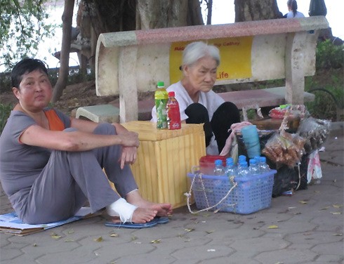 Ở một góc khác của Hà Nội, bên chiếc ghế đá ven hồ Hoàn Kiếm, một cụ bà ngồi bệt ngay vỉa hè, bán vài chai nước, vài gói kẹo mỗi buổi chiều chỉ để kiếm vài đồng bạc lo cho ngày hai bữa cơm tằn tiện.