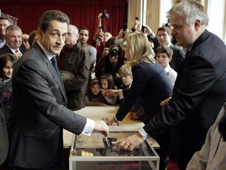 Tổng thống Sarkozy (trái) bỏ phiếu tại điểm bầu cử ở thủ đô Pari ngày 6/5. Ảnh: AFP-TTXVN.