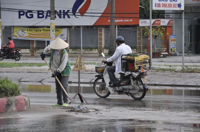 Nhân viên vệ sinh cũng không thể làm gì hơn ngoài việc dọn rác trên đường khi đường bị ngập.