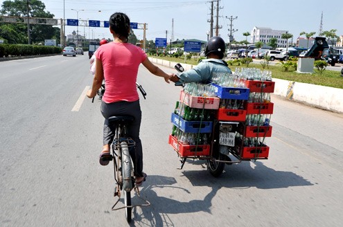Vừa thồ hàng vừa dắt tay người đi xe đạp trên quốc lộ 5 (Hà Nội - Hải Phòng).
