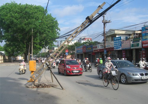 Cột điện đổ gây nguy hiểm cho người đi đường, chụp sáng 9/5/2012 trên đường Trường Chinh (Hà Nội). Ảnh: Lê Hội.