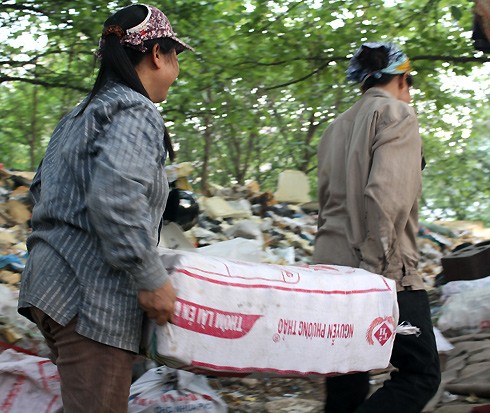 Đa phần dân ở đây là phụ nữ. Họ chấp nhận làm thế chân đổ rác cho công nhân môi trường Hà Nội để được lượm túi nilon, chai lọ từ các xe rác. "Có công nhân thương, tháng nào cũng cho tiền. Một số người thì chỉ cho đổ rác thay họ, chúng tôi cũng thấy may rồi", bà Tám (52 tuổi, Nam Định), một trong những cư dân lâu đời nhất khu, chia sẻ.