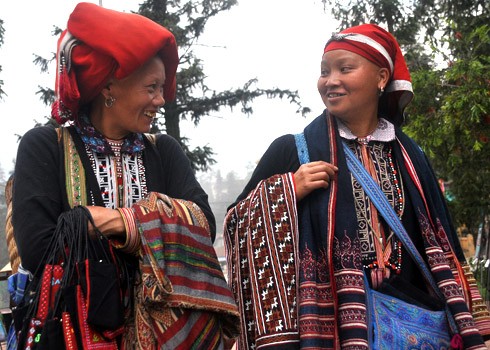 Hai phụ nữ Dao Đỏ trong trang phục truyền thống trò chuyện vui vẻ với nhau tại thị trấn Sa Pa.