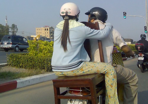 Cách ngồi của người phụ nữ này thật nguy hiểm, chụp tại TP.HCM. Ảnh: Hà Ngọc Sang.