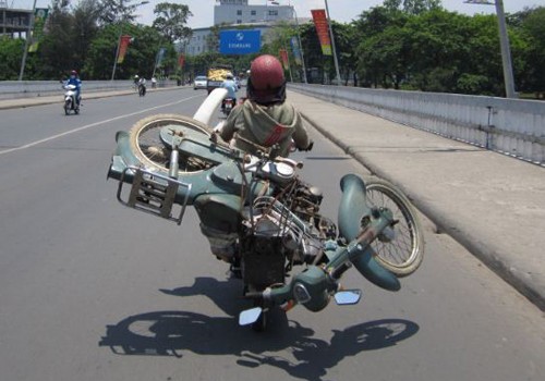 Việc chở cả một chiếc xe máy là rất nguy hiểm, nhất là với phụ nữ tay lái yếu. Ảnh: Nguyễn Dương Hải.