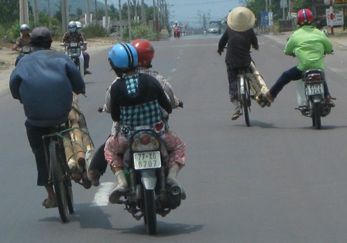 Dàn hàng ngang đẩy xe đạp trên quốc lộ rất nguy hiểm. Ảnh: Duong Huu Thanh.