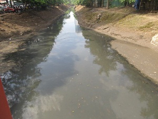 Dòng nước đen ngòm trên một đoạn sông (đường Duy Tân, Cầy Giấy).
