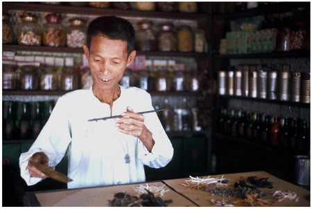 Vị dược sĩ này đang pha chế một bài thuốc từ các loại thảo mộc theo những công thức của riêng mình tại một thôn nhỏ ở phía Nam của Huế.