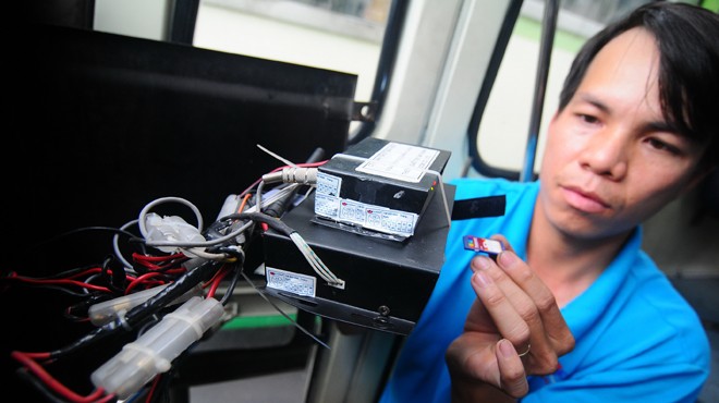 Kỹ thuật viên Nguyễn Ngọc Duy lắp đặt hộp đen giám sát hành trình trên xe buýt tuyến 68, TP.HCM - Ảnh: T.T.D.