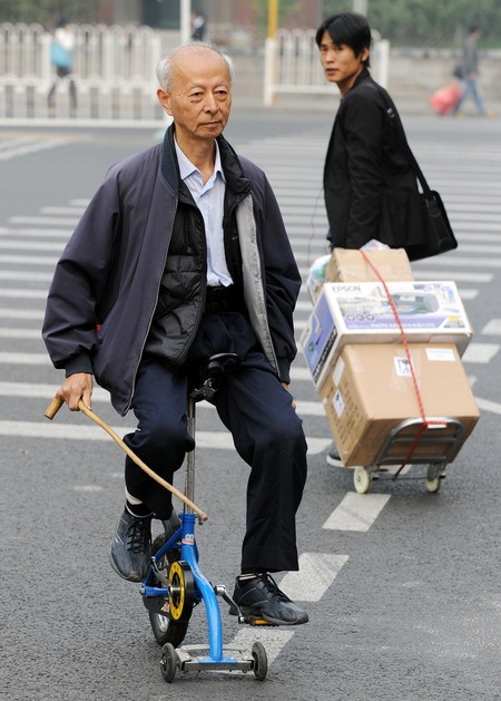 Một cụ già Trung Quốc di chuyển bằng chiếc xe đạp nhỏ xíu ở Bắc Kinh.