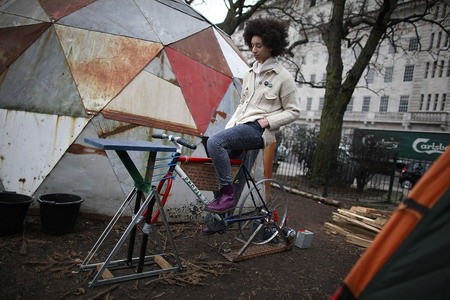 Một cô gái trong phong trào "chiếm London" đạp xe đạp phát điện tại khu trại ở quảng trường Finsbury.