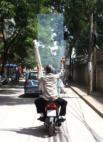2 thanh niên chở tấm kính lớn, chụp tại đường Lê Trọng Tấn, Định Công, Hà Nội. Ảnh: Sơn Ngân.