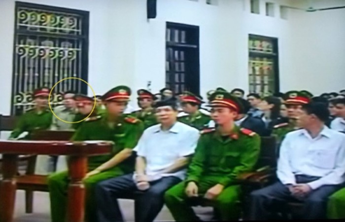 Bị hại Đoàn Văn Vươn ngồi sát cửa sổ phòng xét xử - Ảnh chụp qua màn hình