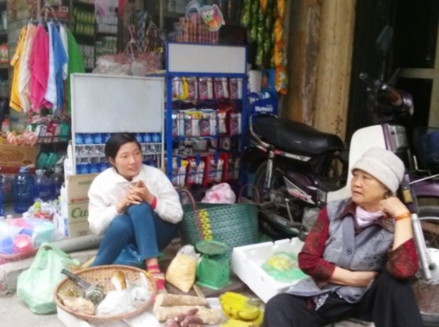 Hai người phụ nữ, một già, một trẻ, bán hàng trong rét sớm hôm
