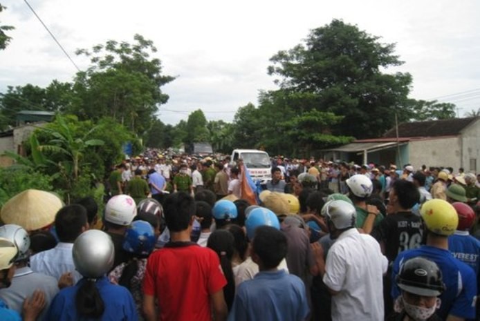 Hàng trăm người kéo đến xem cảnh sát khám nghiệm tử thi ngay ven quốc lộ. Ảnh: Lê Hoàng./Vnexpress