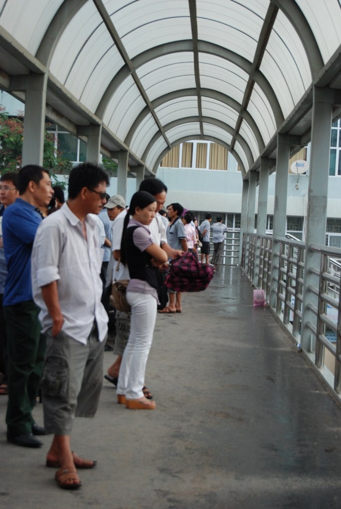 Tại khu vực Hoàng Quốc Việt, nhiều phụ huynh chạy lên cầu đi bộ tránh mưa