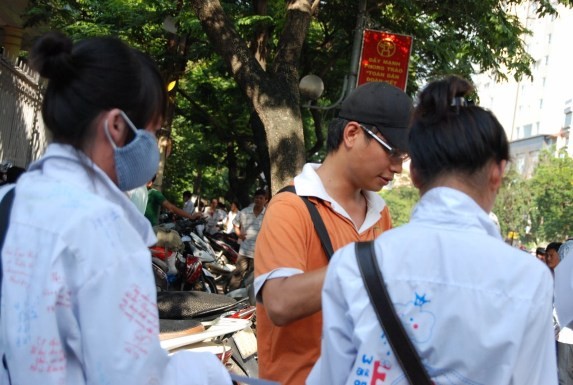 Một thanh niên bán đáp án thi đại học ngay trước cổng Trường ĐH Sư phạm Hà Nội - Ảnh: Đỗ Quyên