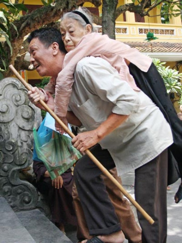 Ông Hùng Quý Tài cõng mẹ già 81 tuổi về quê ăn tết