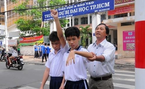 Thầy Nguyễn Phi Hùng hướng dẫn học sinh trong tiết học băng qua đường.