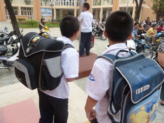 Trẻ oằn lưng cắp sách tới trường (Ảnh: Kim Ngân)