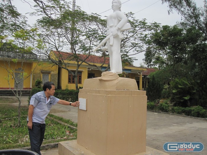 Cựu chiến binh Hoàng Như Lý bên tượng đài liệt sĩ Hoàng Thị Hồng Chiêm đặt tại trường Trung học cơ sở Bình Ngọc (Ảnh: Lại Cường)