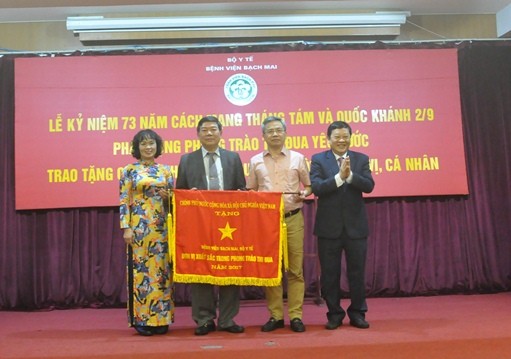 Bà Hoàng Thị Thơm ttrao cờ thi đua của chính phủ cho Bệnh viện Bạch Mai (Ảnh: http://moh.gov.vn)