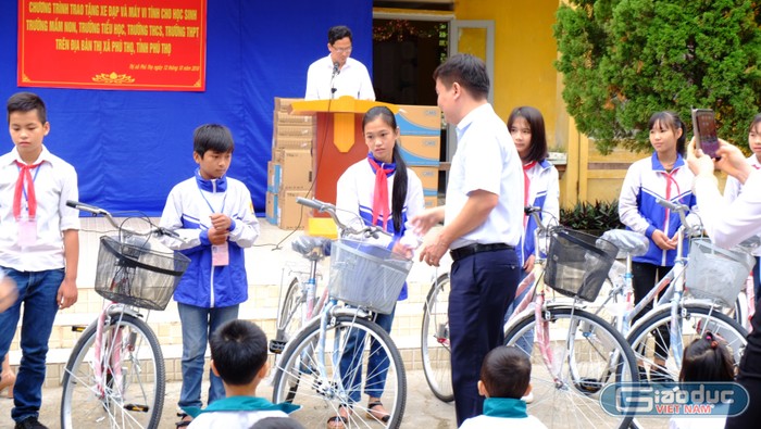 Ông Nguyễn Tiến Bình, Tổng biên tập Báo điện tử Giáo dục Việt Nam trao tận tay xe đạp cho các em học sinh. (Ảnh: LC)