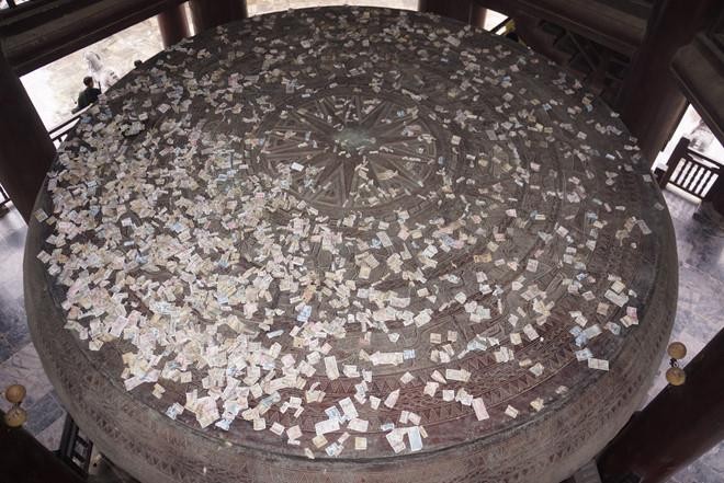Du khách ném tiền lên hình trống đồng ở chùa Bái Đính. (ảnh: LC)