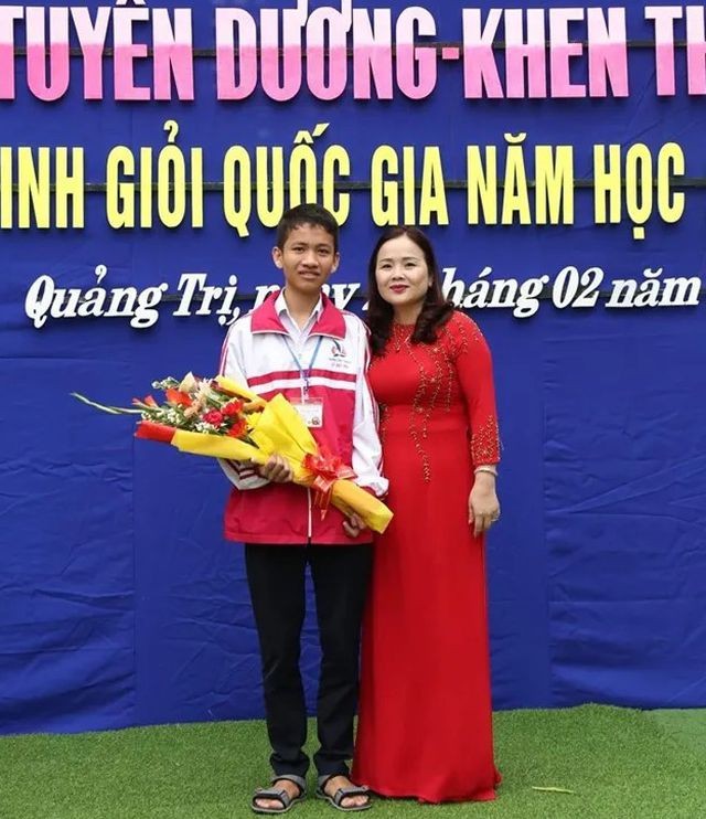 Tiến sĩ Lê Thị Hương, Giám đốc Sở Giáo dục và Đào tạo Quảng Trị tặng hoa và động viên em Thái Xuân Đăng (Ảnh: Sở Giáo dục và Đào tạo Quảng Trị)